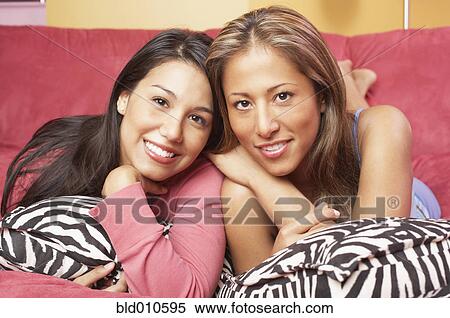 Two women lying together on couch View Large Photo Image Stock Photography - Two women lying together on couch. Fotosearch