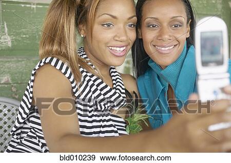 Two women photographing themselves View Large Photo Image Stock Photo - Two women photographing themselves. Fotosearch