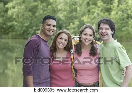 Stock Photography - Two young couples standing by a lake. Fotosearch