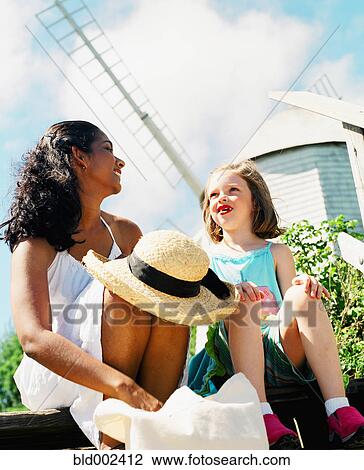 Woman and young girl relaxing in sun View Large Photo Image Stock Image - Woman and young girl relaxing in sun. Fotosearch
