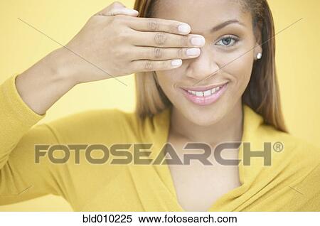 Stock Photography - Woman covering her eye with hand. Fotosearch