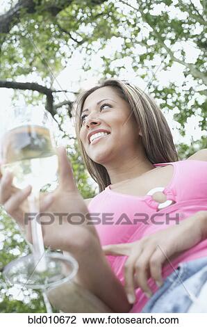 Stock Image - Woman holding a glass of wine. Fotosearch