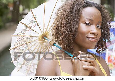 Woman holding a parasol outdoors View Large Photo Image Stock Image - Woman holding a parasol outdoors. Fotosearch