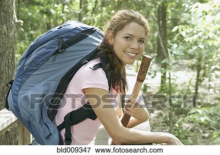 Stock Photo - Woman leaning against a forest railing. Fotosearch
