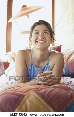 Woman lying on bed View Large Photo Image Stock Image - Woman lying on bed. Fotosearch