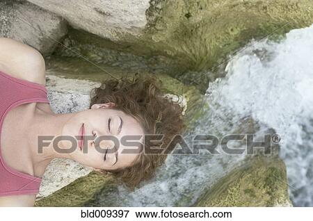 Woman resting her head on a rock View Large Photo Image Stock Photo - Woman resting her head on a rock. Fotosearch