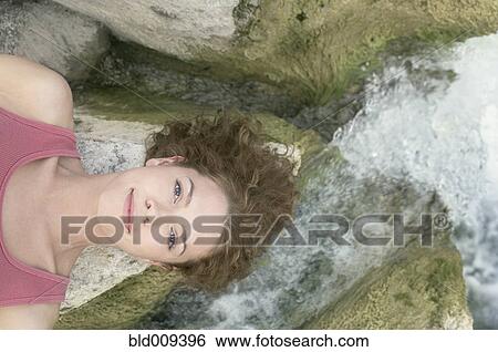 Woman resting her head on a rock View Large Photo Image Stock Photograph - Woman resting her head on a rock. Fotosearch
