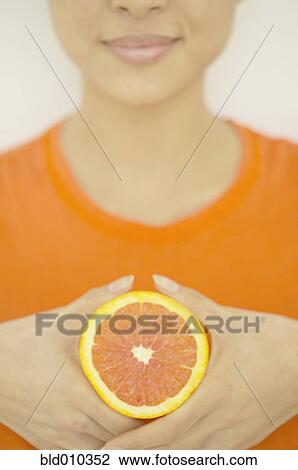 Woman showing a slice of orange View Large Photo Image Stock Image - Woman showing a slice of orange. Fotosearch