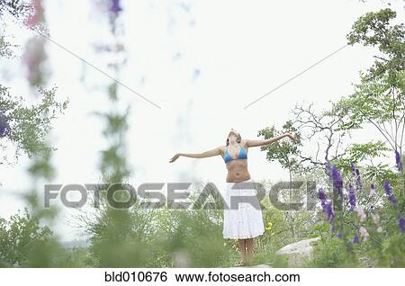Stock Photograph - Woman standing with outstretched arms. Fotosearch