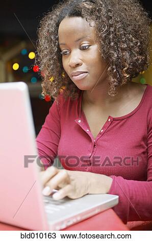 Woman working on a laptop View Large Photo Image Stock Image - Woman working on a laptop. Fotosearch