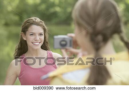 Women taking snapshots in a forest View Large Photo Image Stock Image - Women taking snapshots in a forest. Fotosearch