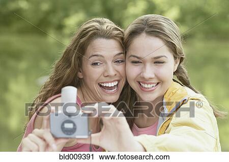 Women taking snapshots in a forest View Large Photo Image Stock Image - Women taking snapshots in a forest. Fotosearch