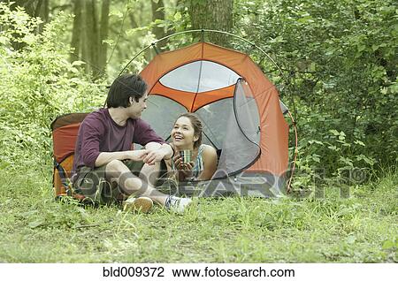 Stock Image - Young couple at their campsite. Fotosearch