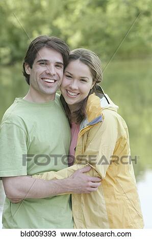 Stock Image - Young couple embracing outside. Fotosearch