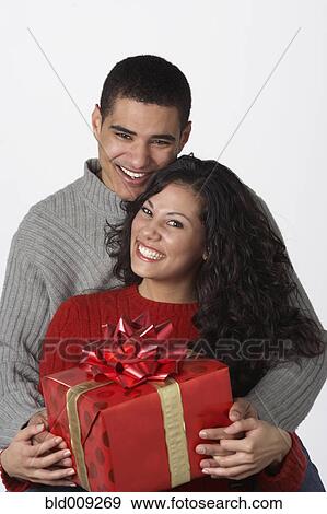 Young couple holding gift View Large Photo Image Stock Photo - Young couple holding gift. Fotosearch
