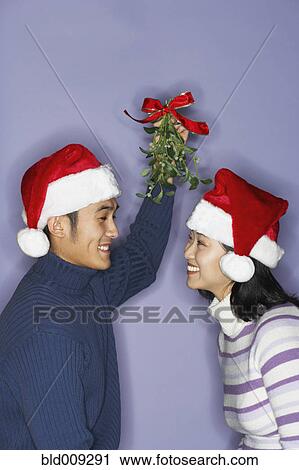 Stock Image - Young couple with mistletoe. Fotosearch
