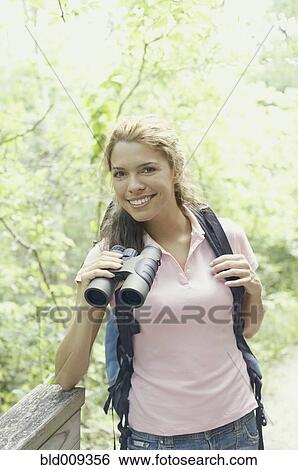 Stock Photograph - Young female hiker using binoculars. Fotosearch