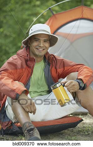 Stock Image - Young man at his campsite. Fotosearch