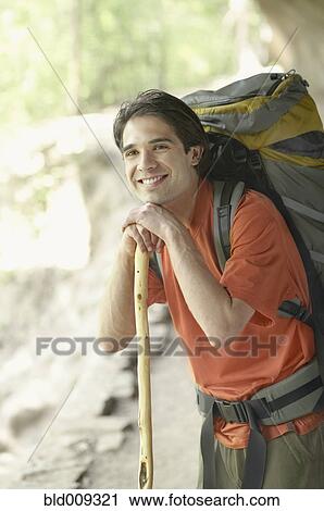 Stock Image - Young man hiking on a trail. Fotosearch