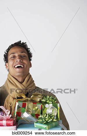 Young man holding gifts View Large Photo Image Picture - Young man holding gifts. Fotosearch