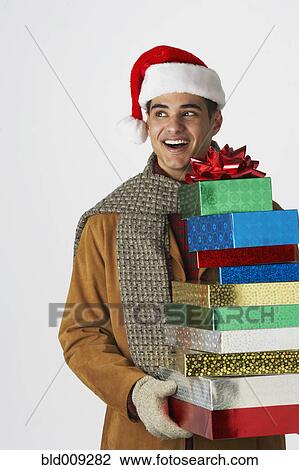 Young man holding holiday gifts View Large Photo Image Stock Image - Young man holding holiday gifts. Fotosearch