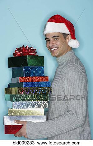 Stock Image - Young man holding holiday gifts. Fotosearch