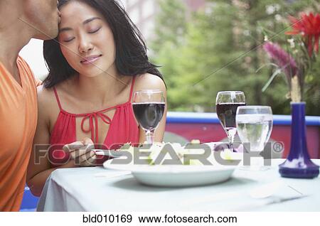 Stock Photo - Young man kissing woman outdoors. Fotosearch