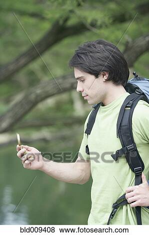 Stock Photo - Young man using a compass. Fotosearch