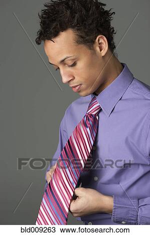 Young man wearing striped tie View Large Photo Image Stock Image - Young man wearing striped tie. Fotosearch