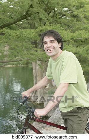 Young man with bicycle in a forest View Large Photo Image Stock Photo - Young man with bicycle in a forest. Fotosearch