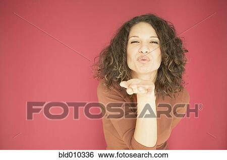 Young woman blowing a kiss View Large Photo Image Stock Photograph - Young woman blowing a kiss. Fotosearch