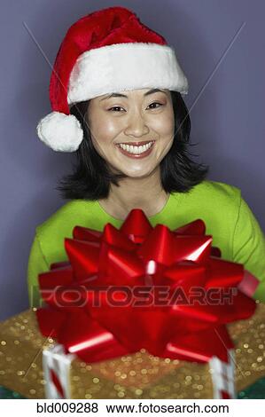 Young woman carrying gift with bow View Large Photo Image Stock Photo - Young woman carrying gift with bow. Fotosearch