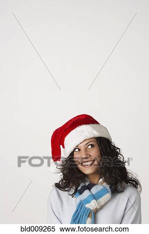 Stock Photography - Young woman dressed in a Santa hat. Fotosearch