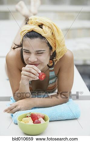 Stock Photo - Young woman eating strawberry. Fotosearch