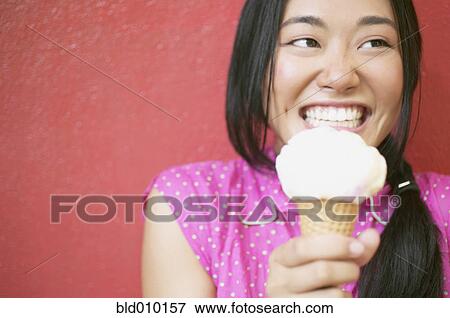 Stock Photo - Young woman enjoying an ice cream cone. Fotosearch
