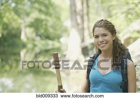 Young woman hiking in a forest View Large Photo Image Stock Image - Young woman hiking in a forest. Fotosearch