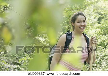 Stock Photo - Young woman hiking in a forest. Fotosearch