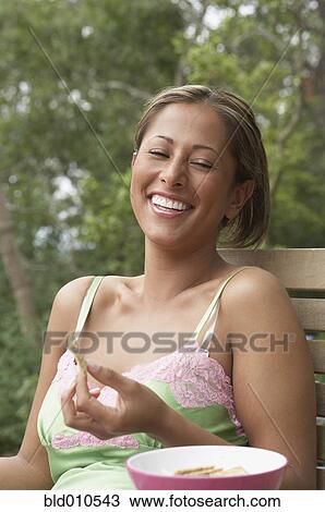 Young woman holding a biscuit View Large Photo Image Stock Image - Young woman holding a biscuit. Fotosearch