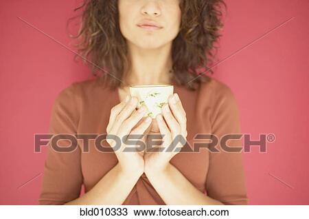 Young woman holding a cup View Large Photo Image Stock Image - Young woman holding a cup. Fotosearch