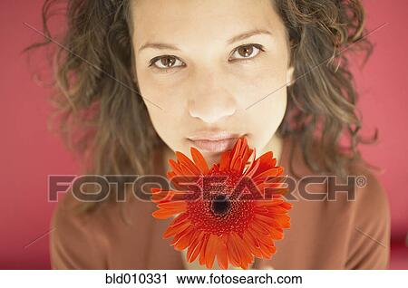 Stock Image - Young woman holding a flower. Fotosearch