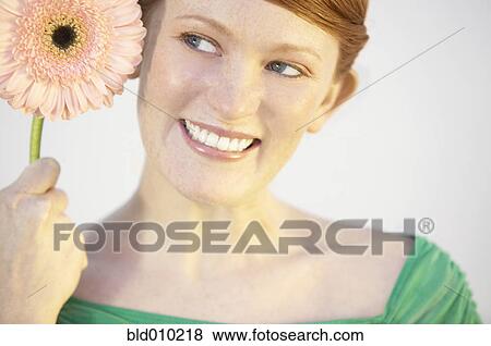 Stock Photo - Young woman holding a flower. Fotosearch