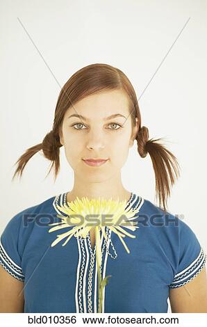 Stock Photograph - Young woman holding a flower. Fotosearch