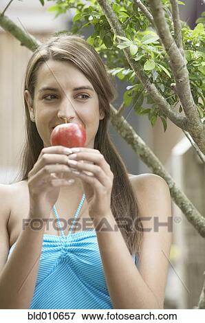 Young woman holding apple View Large Photo Image Stock Photo - Young woman holding apple. Fotosearch