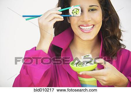 Stock Photo - Young woman holding chopsticks. Fotosearch