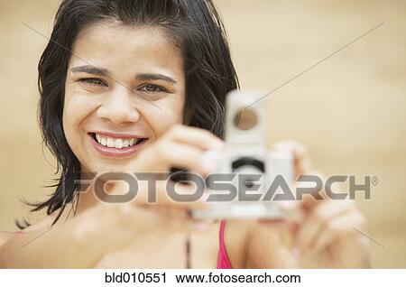 Young woman holding digital camera View Large Photo Image Stock Image - Young woman holding digital camera. Fotosearch