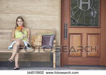 Young woman holding flowers View Large Photo Image Stock Image - Young woman holding flowers. Fotosearch
