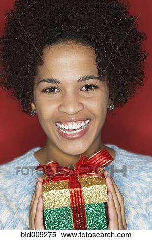 Stock Photography - Young woman holding gift. Fotosearch