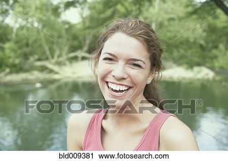 Young woman laughing outdoors View Large Photo Image Stock Image - Young woman laughing outdoors. Fotosearch