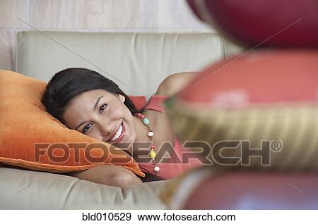 Young woman lying down on couch View Large Photo Image Stock Photo - Young woman lying down on couch. Fotosearch