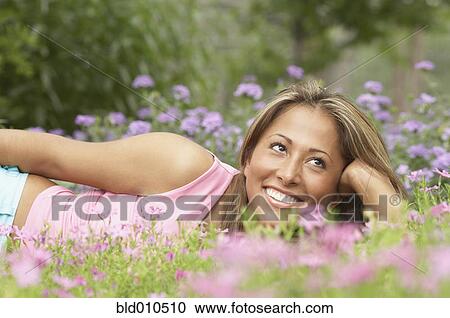 Young woman lying on the grass View Large Photo Image Stock Image - Young woman lying on the grass. Fotosearch